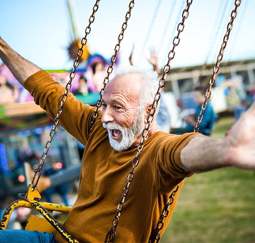 Happy old man in chain swing